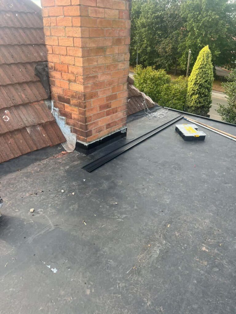 This is a photo of a flat roof which has just been repaired, there is also a chimney stack and some leadwork has also been dressed. Works carried out by Oxted Roofing Repairs