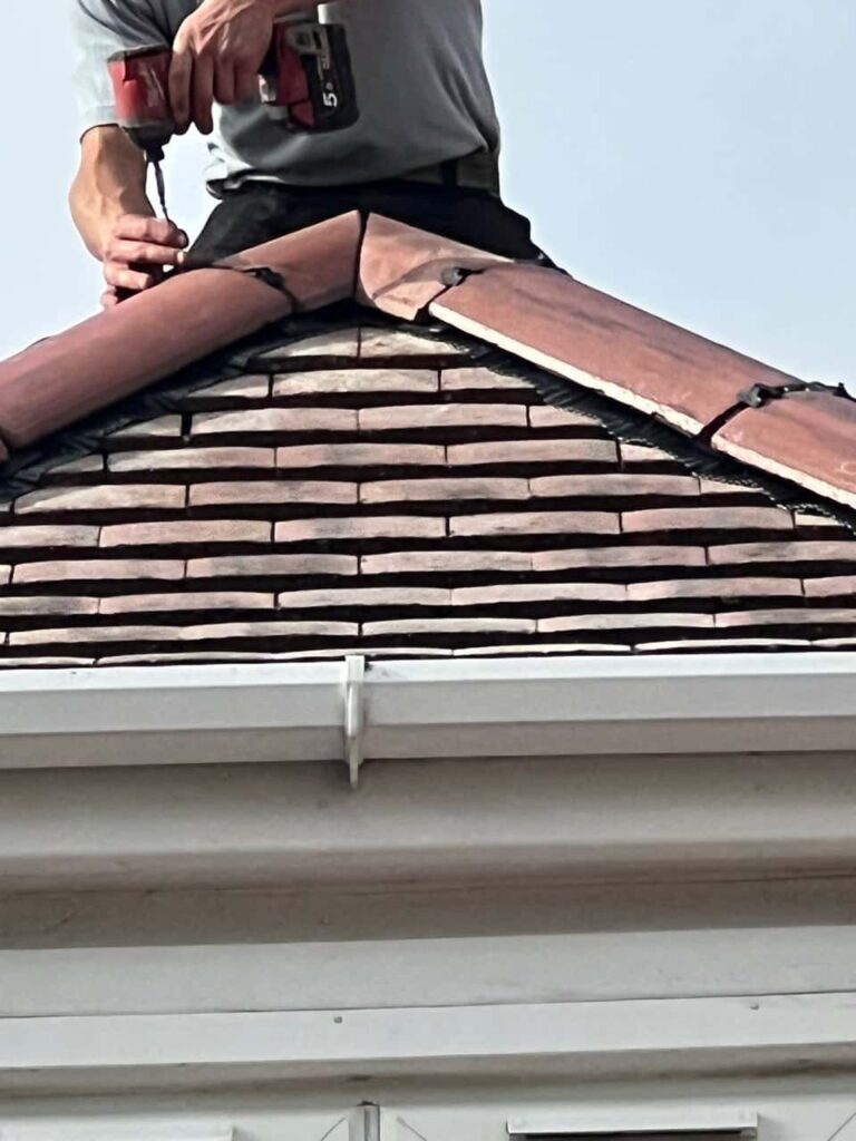 This is a photo of one of the operatives of Oxted Roofing Repairs installing new ridge tiles